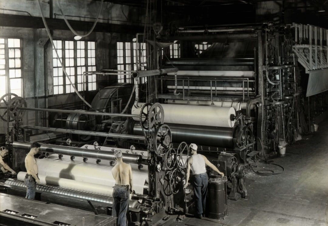 Historische Druckmaschine mit Arbeitern in einer Zeitungspresse